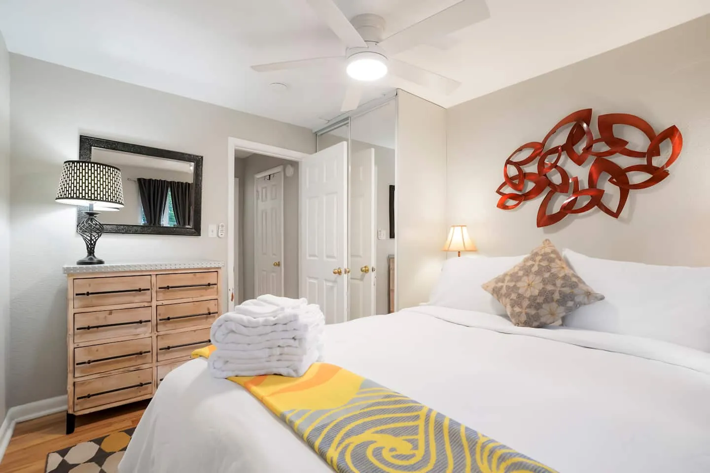 Queen bedroom with bedside lamps and a ceiling fan