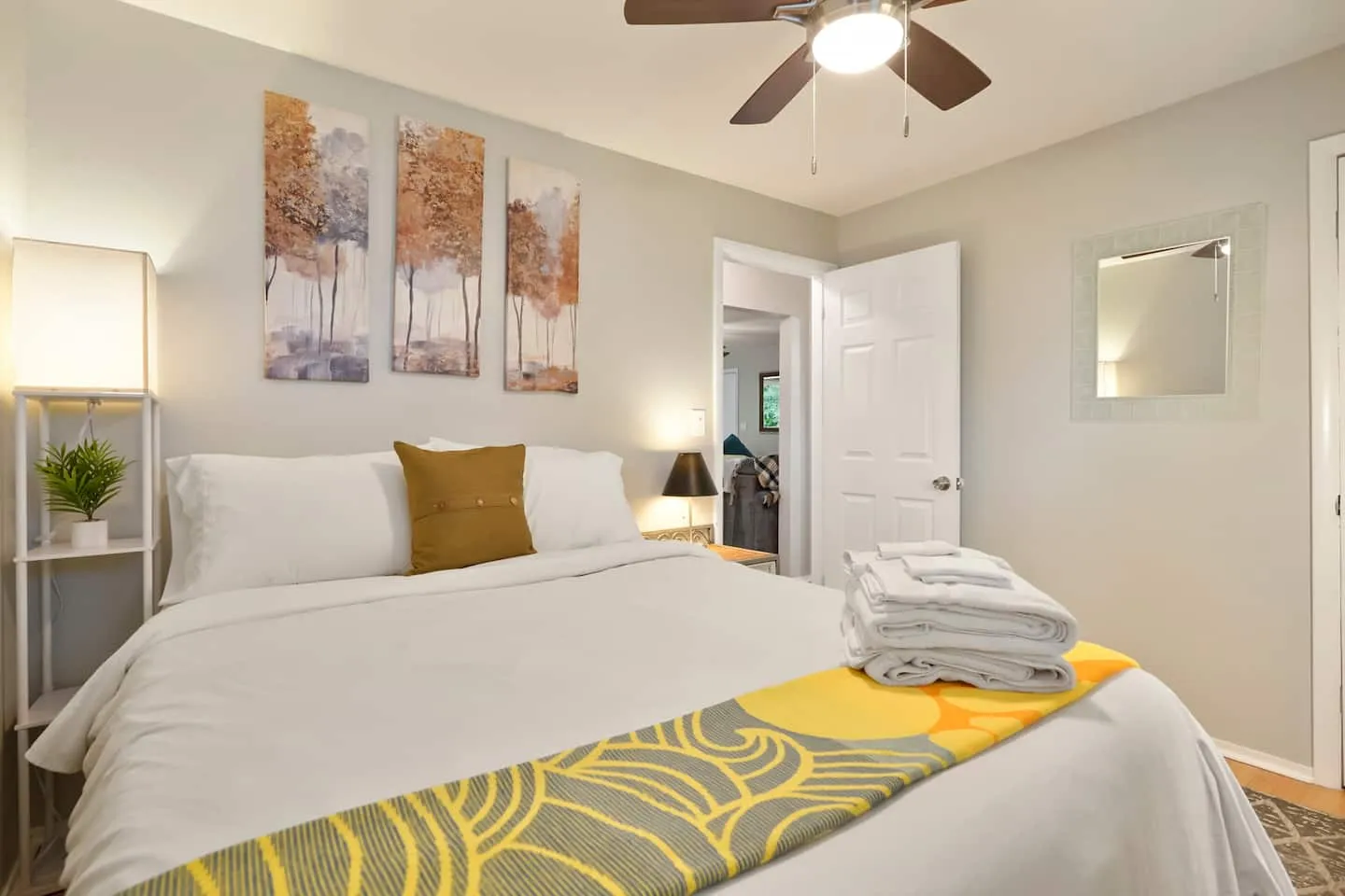 Queen bedroom with a ceiling fan and fresh linens