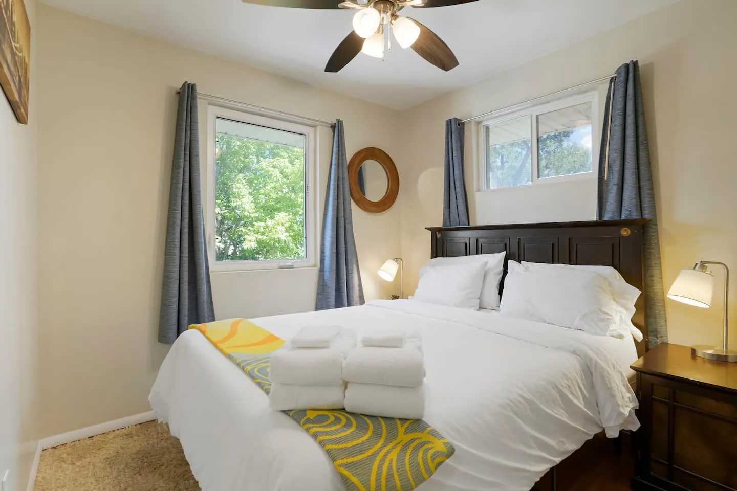 Queen bedroom with a ceiling fan and two windows